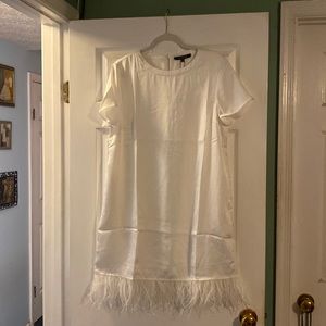 White short sleeve dress with feather trim bottom in size large